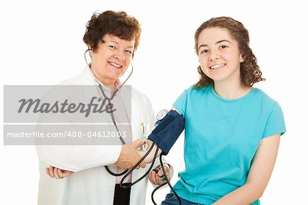 Friendly female doctor and her happy teenage patient, smiling as the doctor checks the girl's blood pressure.  Isolated.