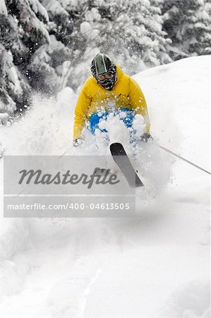 Freeride Skier moving down and  jumping in powder snow.
