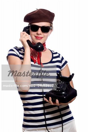 beautiful girl with red bandana, beret and striped shirt in a classic 60s french look is holding an old rotary phone