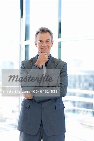 Smiling senior businessman standing in office