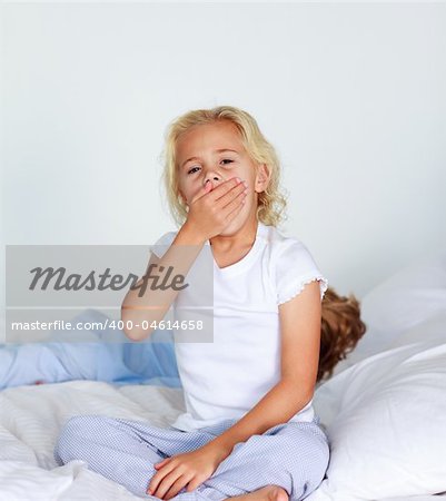 Little blonde girl very tired in bed