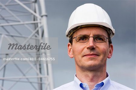 Smiling engineer in front of construction of steel