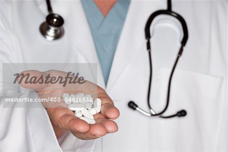 Male Doctor Abstract with Stethoscope and Pills in the Palm of His Hand.