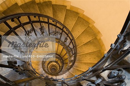 Spiral staircase, forged handrail and stone steps in old tower
