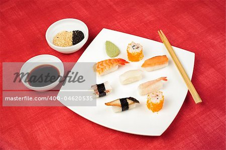 assorted sushi lying at the white square plate