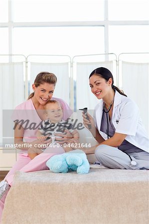 Baby with pediatrician and nurse in hospital with copy-space