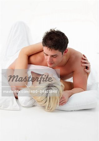 Attractive boyfriend hugging his girlfriend in bed