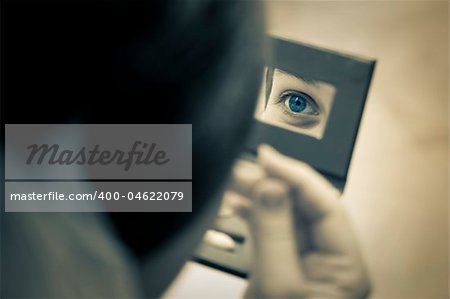 woman eye captured in the mirror / vintage split toned