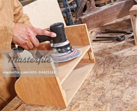 detail of industrial scene, caucasian carpenter work with grinder