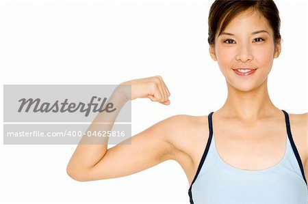 A pretty asian girl flexes one arm on white background