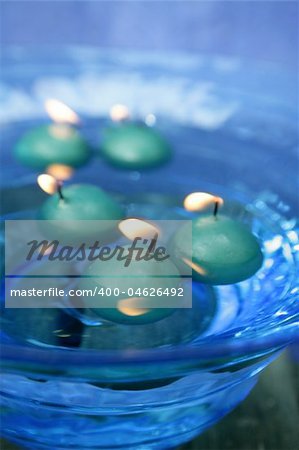 green candles over blue glass bowl of water