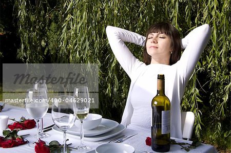 Beautiful woman is enjoying wine and the sun in a garden