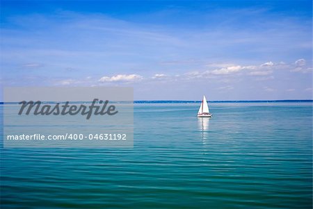 Blue landscape with sailboat.