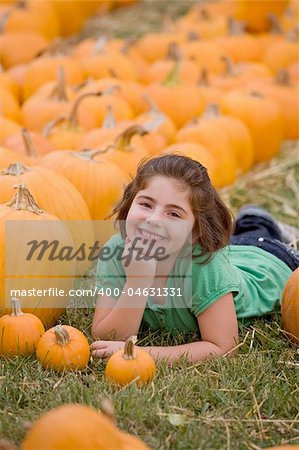 Little Girl Laying Down in the Pumpkin Patch