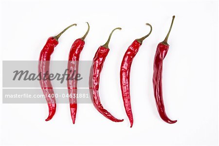 5 Red chili peppers in a row on white