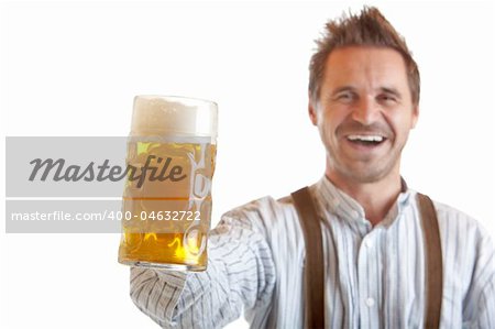 Bavarian man dressed with leather trousers is holding an Oktoberfest Beer Stein into camera. Isolated on white background.