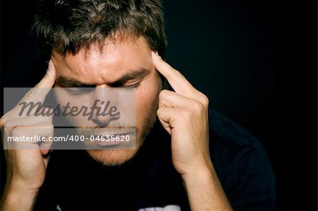 An unhappy depressed young man with a dark background