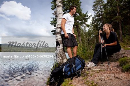 A couple on a camping trip - taking a break by a lake