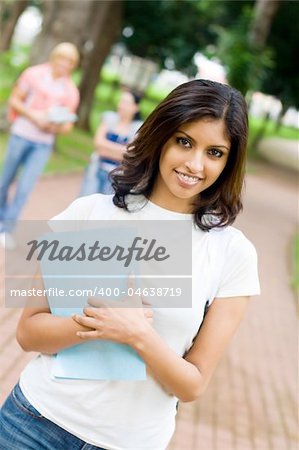 indian female college student on campus, background is her friends