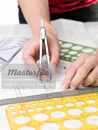 Male architect working on a bluprint, close up on hand and bluprint.