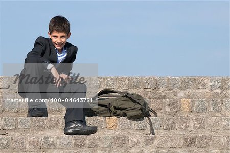 a successful school student is sitting on the stones