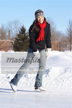 Winter fun - Ice skating. Young woman ice skating outside on a sunny winter day in Quebec City.