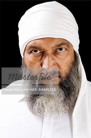 Portrait of Middle Eastern man with headdress, over black background