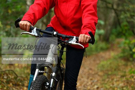 Biking. Woman on mountainbike in autumn forest.