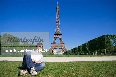 Young man lying on the Champs de Mars. Eiffel tower in background