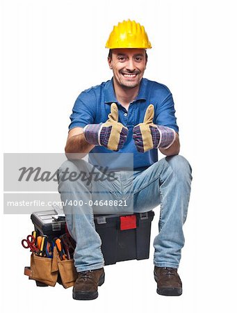 positive and confident young caucasian handyman sit on toolbox