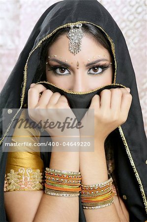 Beautiful brunette asian girl with black veil on face, traditional indian costume