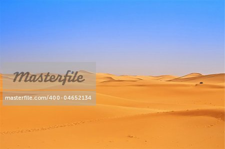 wide view of sand dunes, footsteps in foreground