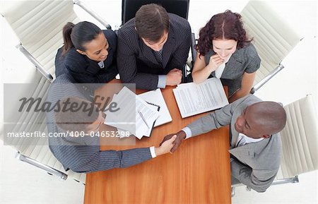 High angle of two businessmen shaking hands in a meeting. Agreement in  business