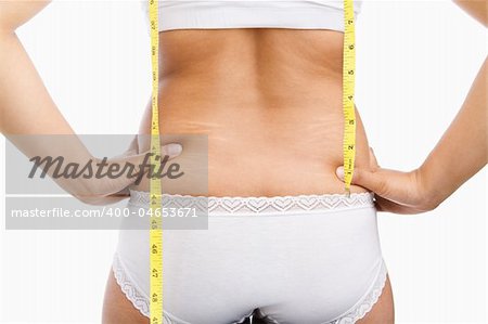 Woman back with cellulite and mesuring tape on under wear over white background