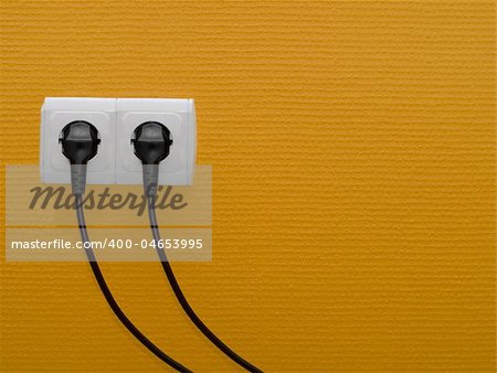 Two electric outlets on orange wall