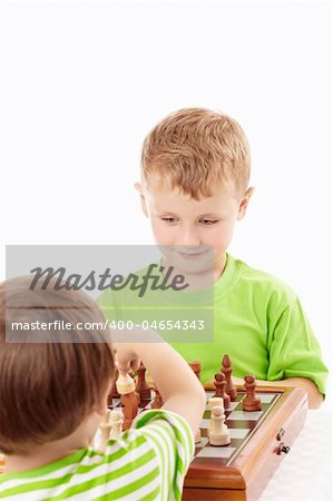 Two joyful little boys play chess, isolated