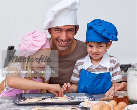 Father and daughter and son baking cookies in the kitchen