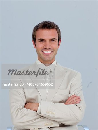 Portrait of smiling young businessman with folded arms