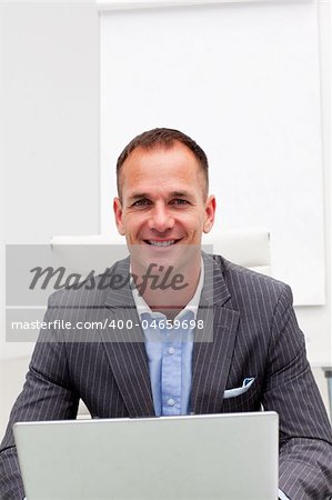 Confident businessman using a laptop in the office