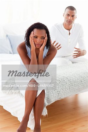 Angry couple sitting on the bed after having a row