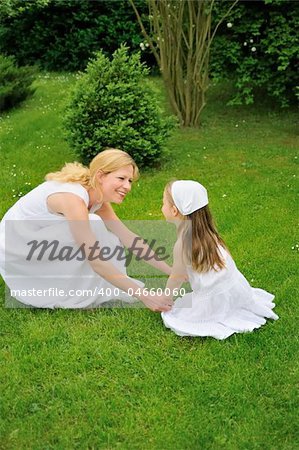 Young mother and daughter playing in meadow