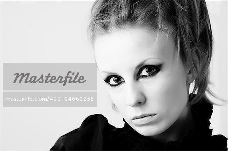 Black and white portrait of young woman with defiant makeup