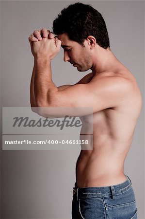 Shirtless man hold his hands on the head on a grey isolated background