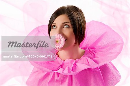 funny shot of a young nice girl looking up with pink collar paper keeping a flower in her mouth