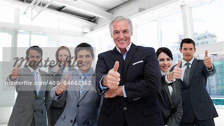 Happy multi-ethnic business team with thumbs up in the office