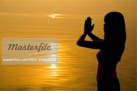 silhouette of a girl praying on a beach