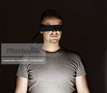 portrait of young blind man on dark background