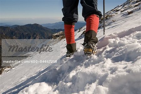Mountain climber foot walk on snow slap.