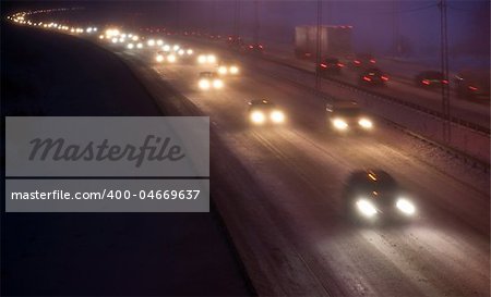 Heavy traffic on the highway in a hevy snowstorm at night