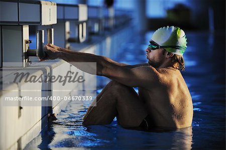 start position race concept with fit swimmer on swimming pool
